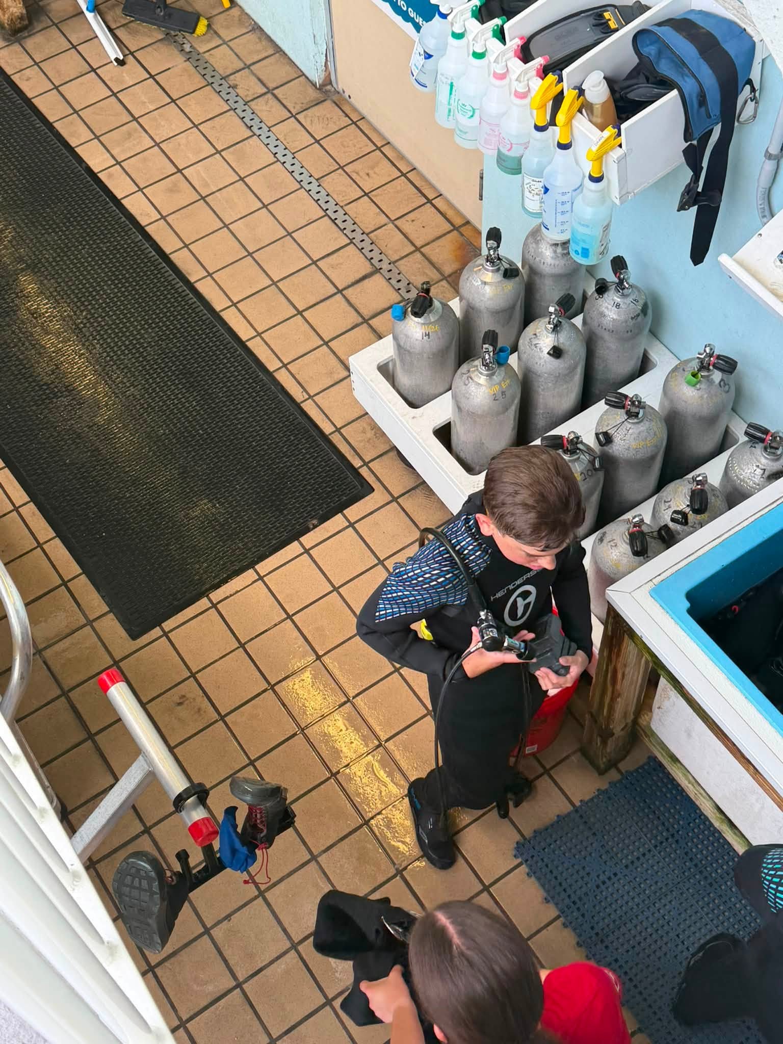 Gear check beside the tank rack before a CMA habitat dive.